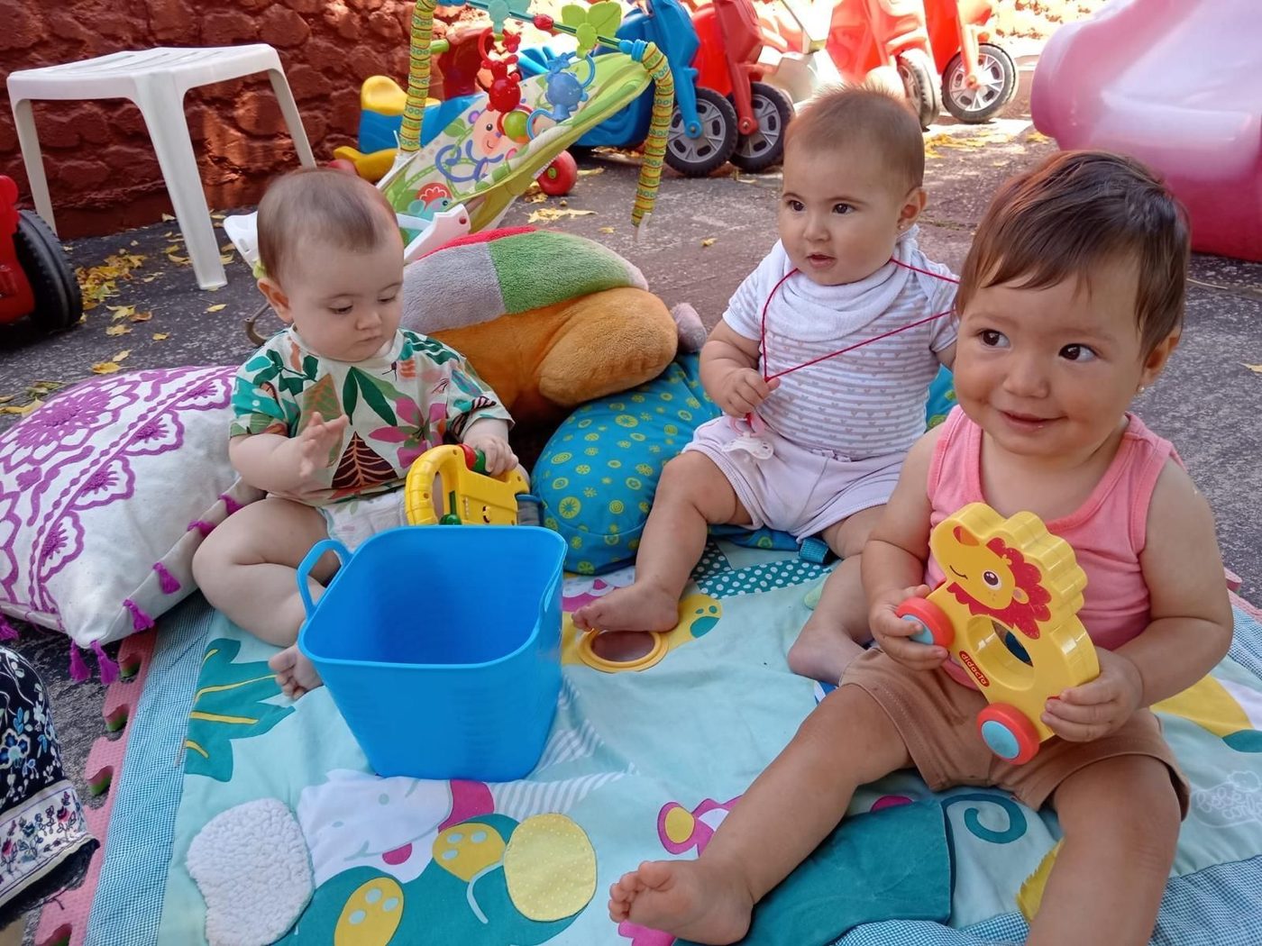 Bebés jugando sobre una manta en el patio