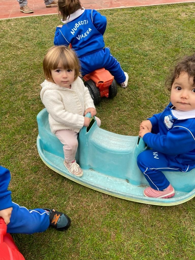 Dos niños jugando en el subibaja del patio
