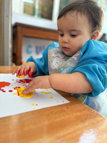 Bebé pintando con las manos en la mesa